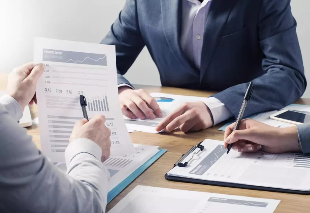 Personen analysieren Finanzberichte mit Diagrammen in einer Besprechung