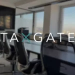 Modern office with conference table and chairs, text 'TAXGATE' in the foreground