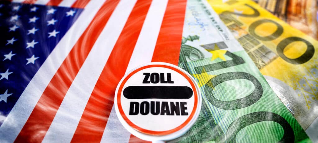 US-Flagge, Euro-Scheine und ein rundes Zollzeichen "Zoll/Douane", das internationalen Handel oder Zölle symbolisiert.